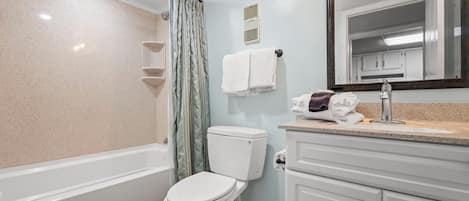 A bathroom with a bathtub, toilet, and sink.