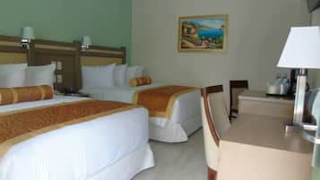 Ein Hotelzimmer mit zwei Betten, einem Schreibtisch und einem Bild an der Wand.