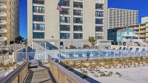 Un hôtel situé en bord de mer, doté d’une piscine, d’une promenade en bois et offrant une vue sur l’océan.