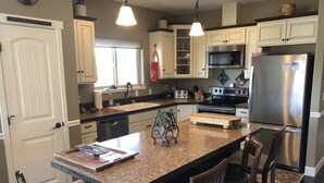 A modern kitchen with granite countertops, stainless steel appliances, and wooden cabinetry. - Vacation and Business Get-A-Way/Lay-Over (John Day)