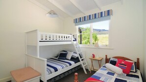 A bunk bed room with a window, a small table, and a lamp. - Spring Grove Dairy - Picturesque views! (Kangaroo Valley)