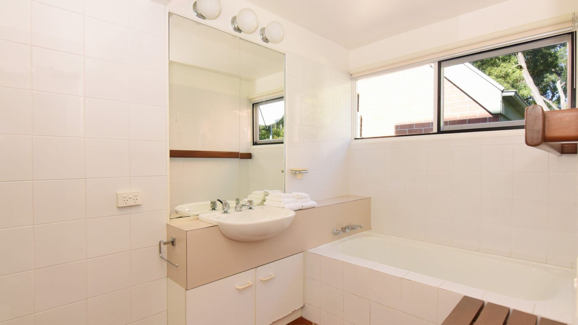 Ein Badezimmer mit Waschbecken, Spiegel und Badewanne.