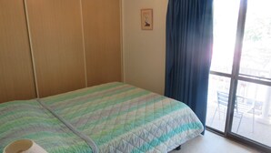Een kamer met een bed, een raam met uitzicht en een deur.