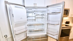 A modern kitchen with a built-in refrigerator, oven, and microwave. - Beachfront condo with multiple beach views (Gulf Shores)