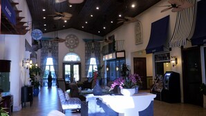 A spacious lobby with a high ceiling, multiple ceiling fans, and a reception desk. - Your new vacation home at Paradise Palms Resort? (Kissimmee)