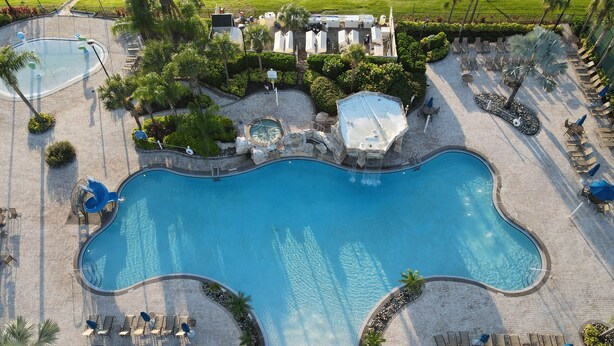 A large outdoor swimming pool with multiple lounge areas and a water slide. - Your new vacation home at Paradise Palms Resort? (Kissimmee)