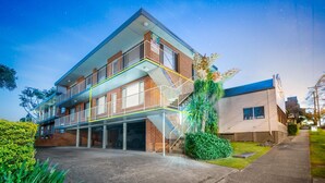 A modern two-story building with a covered outdoor area, a staircase, and a small adjacent structure. - TRAVELLERS PALMS UNIT 1 - RECENTLY RENOVATED (SOUTH WEST ROCKS)