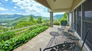 A covered patio with a view of mountains, outdoor furniture, and a stone pillar. - The Perch - 3 BR, 3 BA One Level Home, Panoramic Long-Range Mountain View (Waynesville)