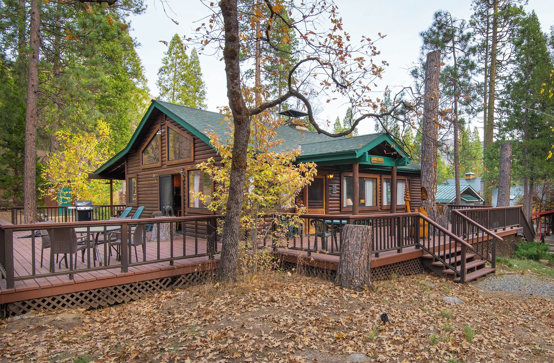 A cabin with a deck, a covered porch, and a staircase leading to the main building.