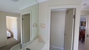 A bathroom with a large mirror, a bathtub, and a toilet. - OCEANSHORES 18 LOVELY THREE BEDROOM UNIT CLOSE TO TOWN (SOUTH WEST ROCKS)