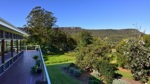 A modern building with large windows overlooking a lush garden and a distant mountain range. - Budderoo - Unique with 270 degree views! (UPPER KANGAROO RIVER)