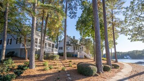 A waterfront property with a covered porch, a stone pathway, and a view of the lake.