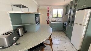Eine Küche mit Mikrowelle, Toaster, Spüle, Herd und Kühlschrank.