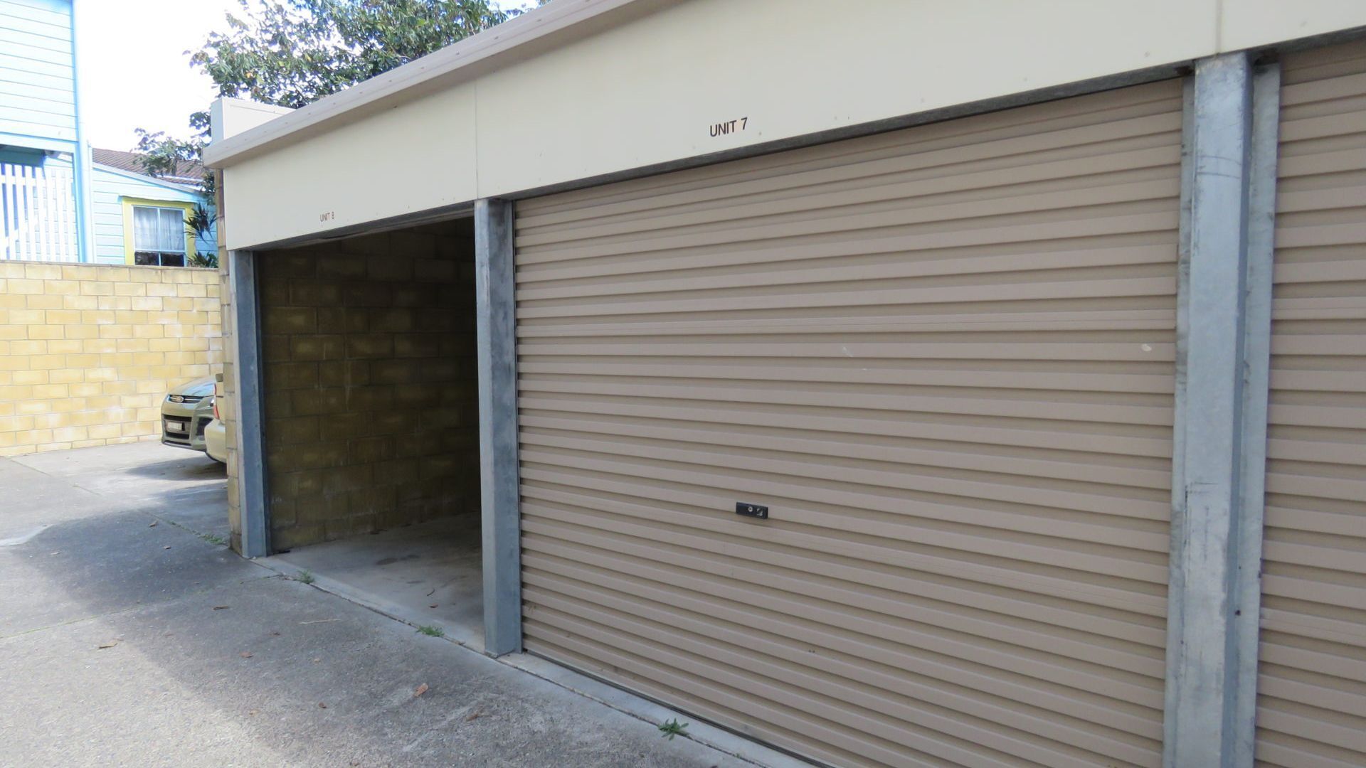 Lukket garageport med metalramme og beige facade.