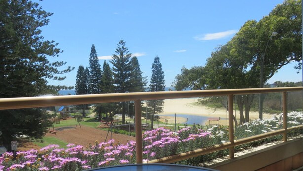 A balcony with a view of a beach, trees, and a playground. - POINT BRINER UNIT 3 - THREE BEDROOM WITH MAIN BEACH VIEWS (South West Rocks)