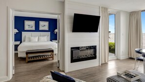 Hotelkamer met een bed, een open haard, een televisie en uitzicht op het landschap.
