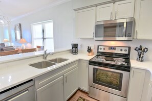 Enjoy cooking in this well-equipped kitchen with a stainless steel stove, microwave, and double sink.