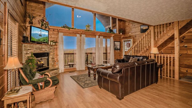 A spacious living room with a fireplace, a leather sofa, a wooden coffee table, and a television. - ⛰️A Bird Song: Spectacular Views | Minutes from Pigeon Forge & Gatlinburg🌲 (Sevierville)
