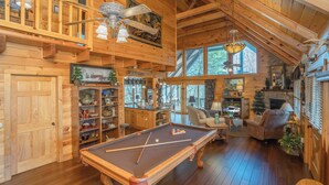 A wooden interior with a pool table, a fireplace, and a cozy seating area. - 🌲Night Moves Over The Smokies 🌙 Hot Tub, Pool Table & Porch Swing (Sevierville)