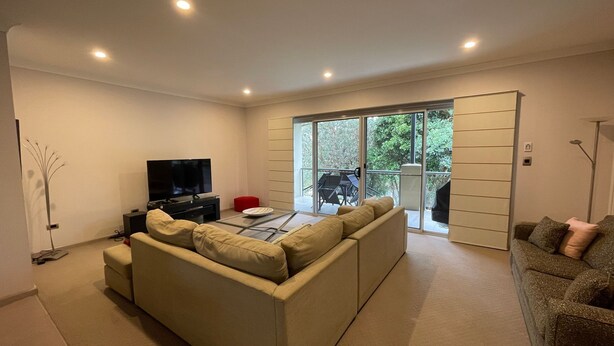 Una sala de estar moderna con un sofá, un televisor y una mesa de comedor.