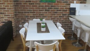 A dining area with a white table, four white chairs, and a small potted plant on the table. - BIRCHGROVE 3 - 400 METRES TO BEACH (SOUTH WEST ROCKS)