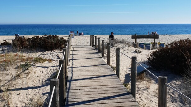 A wooden boardwalk leading to a sandy beach with a clear blue sky. - "Luz House" charming apartment with Jacuzzi (Luz (Luz de Tavira))