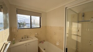 A bathroom with a bathtub, a sink, a window, and a shower area. - WOODY WONDER UNIT 8 - TOP FLOOR GREAT LOCATION (SOUTH WEST ROCKS)