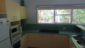 Cocina compacta con ventana, microondas, estufa y alacenas.