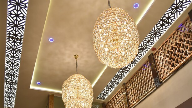 Ein modernes Interieur mit einer Chandelier, einem Empfangstresen und einer Couch.