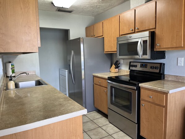 Enjoy cooking in this well-equipped kitchen with a refrigerator, microwave, oven, and dishwasher.
