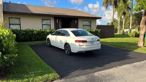Une voiture blanche était garée dans l’allée menant à une maison dont la porte portait le numéro 1240.