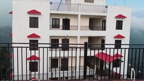 A multi-story building with balconies and a red roof. - S L Residency (Dhari)