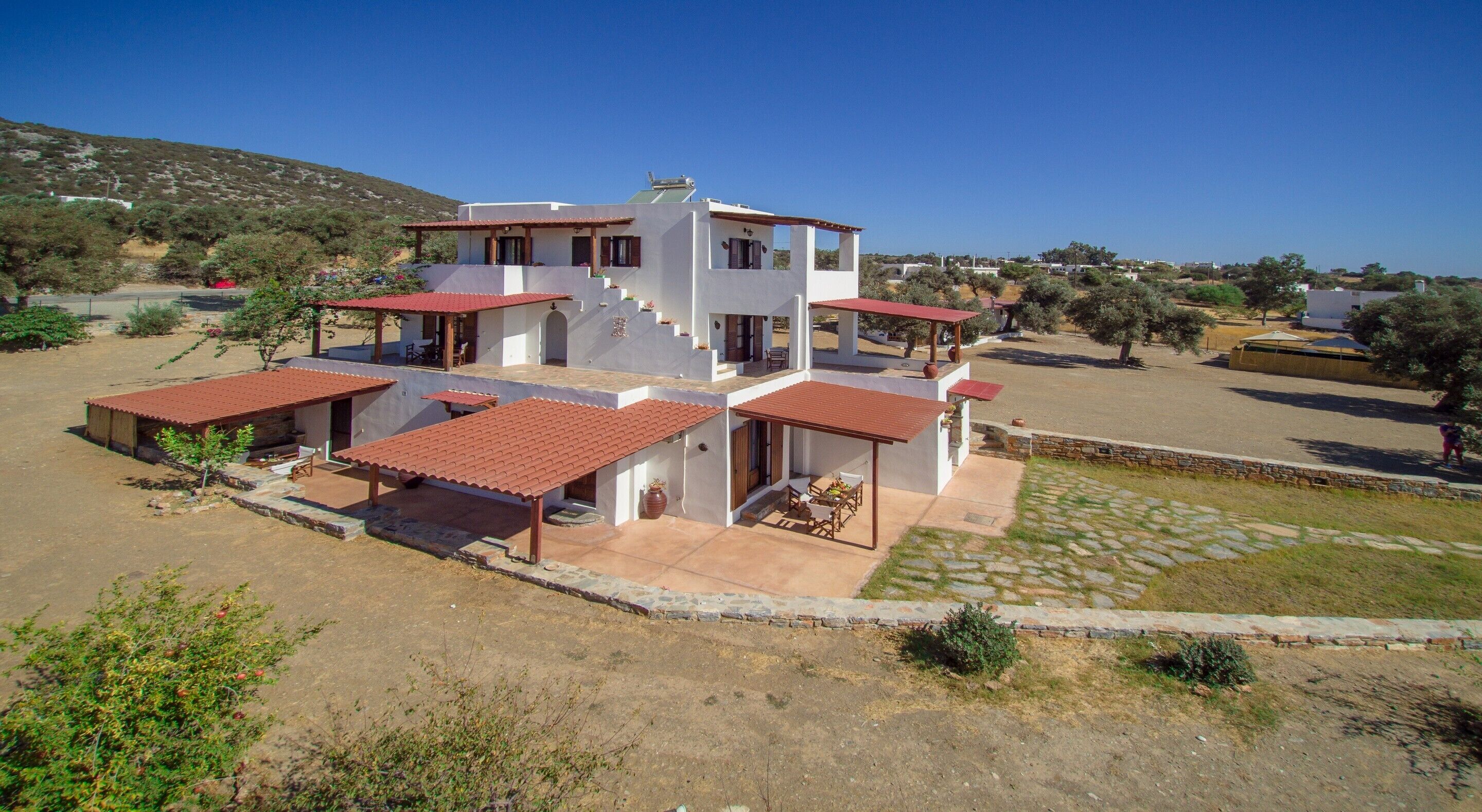 A two-story house with a patio area and a covered outdoor seating space.