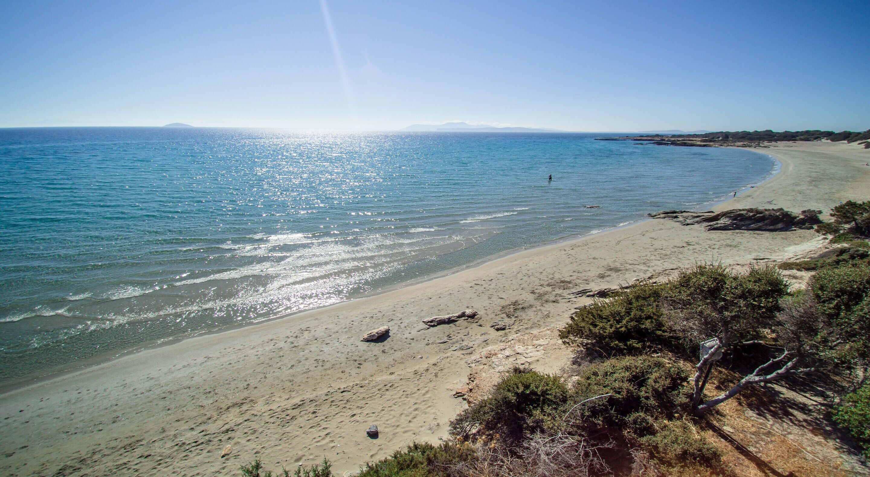 Une plage avec un ciel dégagé et une mer calme.