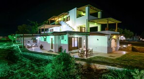 Une maison moderne à deux étages, dotée d’un patio couvert et d’une piscine.