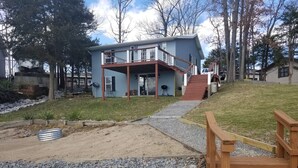 A two-story house with a covered porch and a wooden deck.