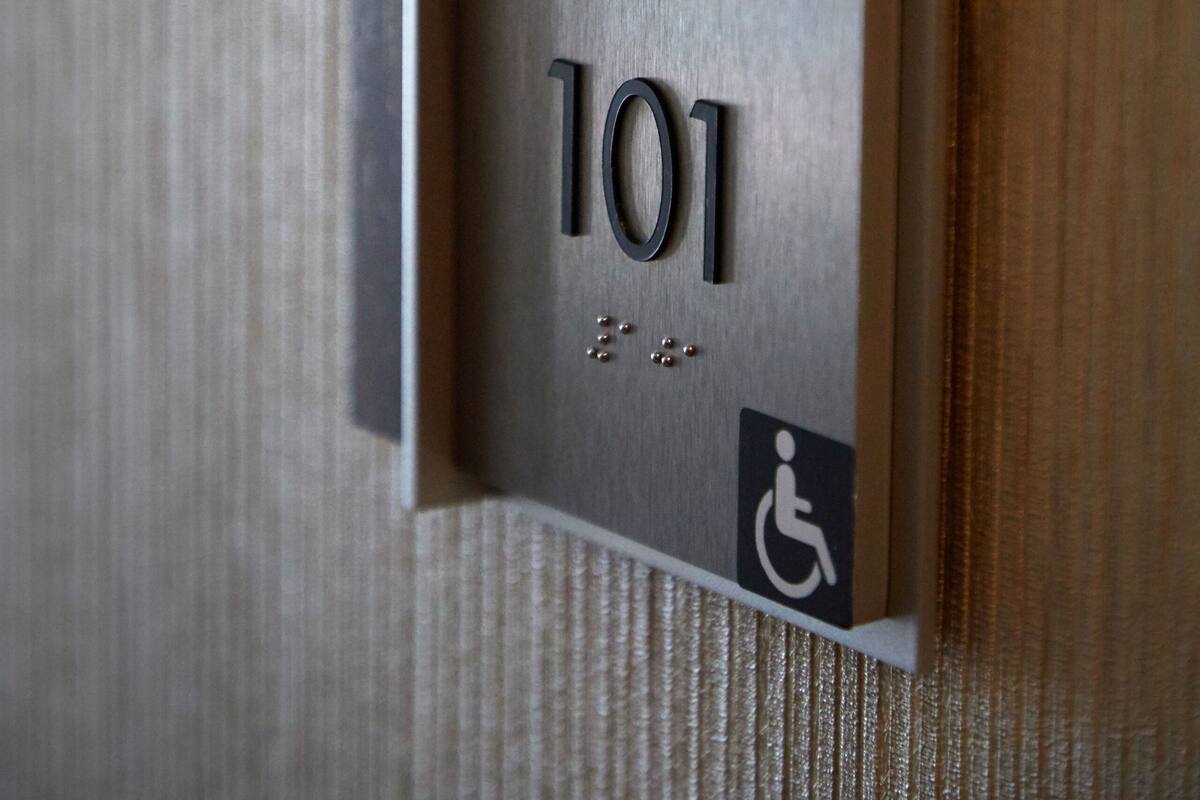 Primer pla d'un senyal de número de habitació amb el número 101 i un símbol d'accessibilitat per a persones amb mobilitat reduïda.