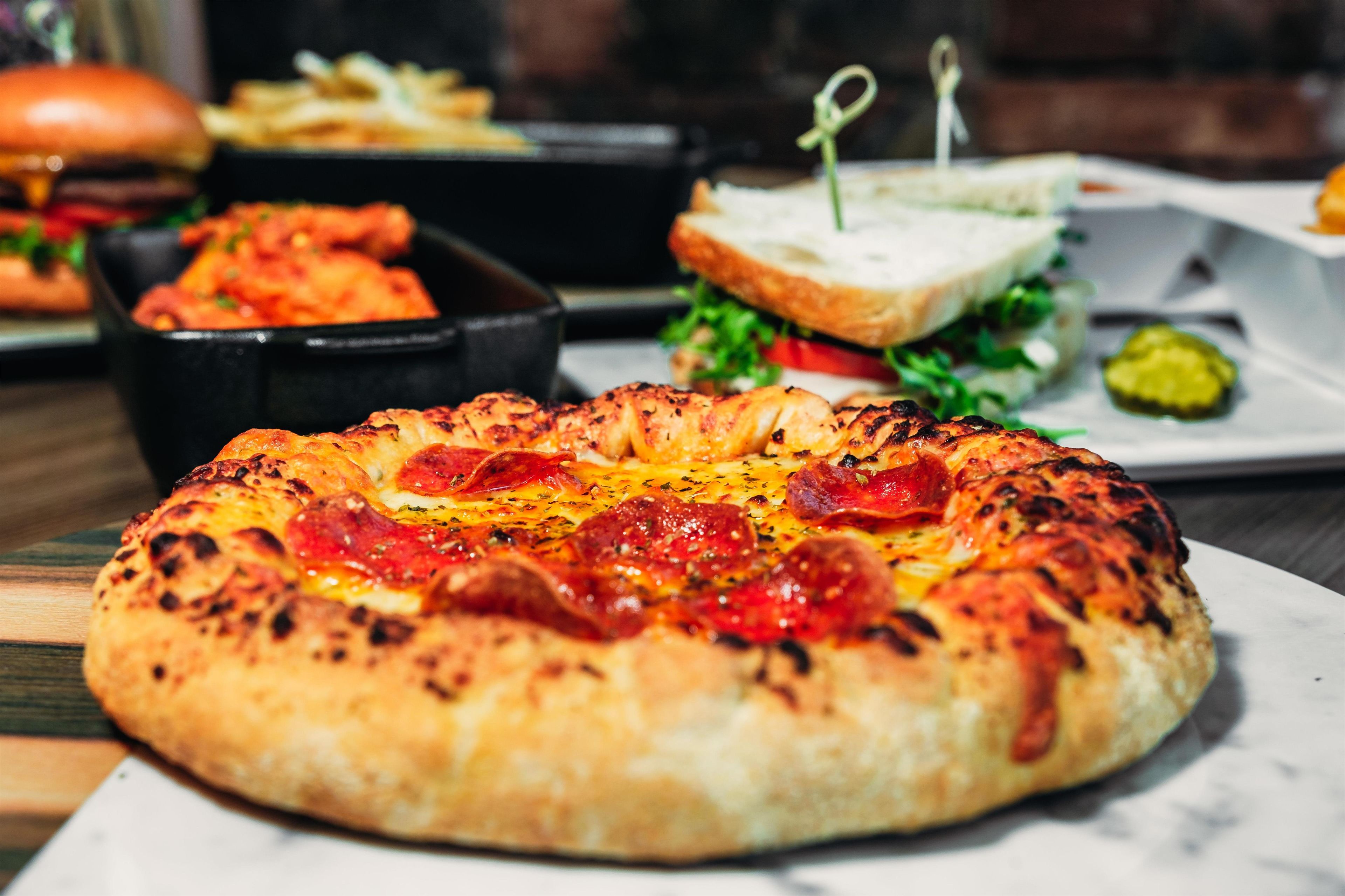 A pizza with pepperoni and cheese on a white plate.