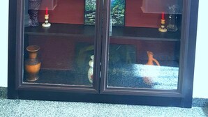 A display cabinet with glass doors, containing various decorative items and figurines. - Hotel Antalia (Tbilisi)
