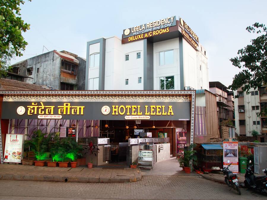 Hotel Leela with a signboard indicating it offers deluxe A/C rooms and multi-cuisine wine & dine.