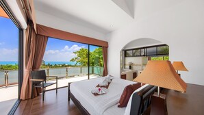 A hotel room with a large bed, a chair, a desk, and a view of the ocean. - Sunny Banks - 4 Bed Private Pool Sea View Villa (Ko Samui)