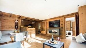 A wooden interior with a sofa, dining table, and a sign for 'Pepsi's Suites.' - Type 2 -1 bedroom, DG, 2-4 Pax - Pepi's Suites Lechtal Apartments (Holzgau)