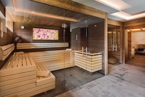 A modern spa room with a wooden bench, glass walls, and a television screen. - Type 2 -1 bedroom, DG, 2-4 Pax - Pepi's Suites Lechtal Apartments (Holzgau)