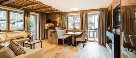 Un'ampia zona giorno con soffitto in legno, un tavolo da pranzo e un camino.