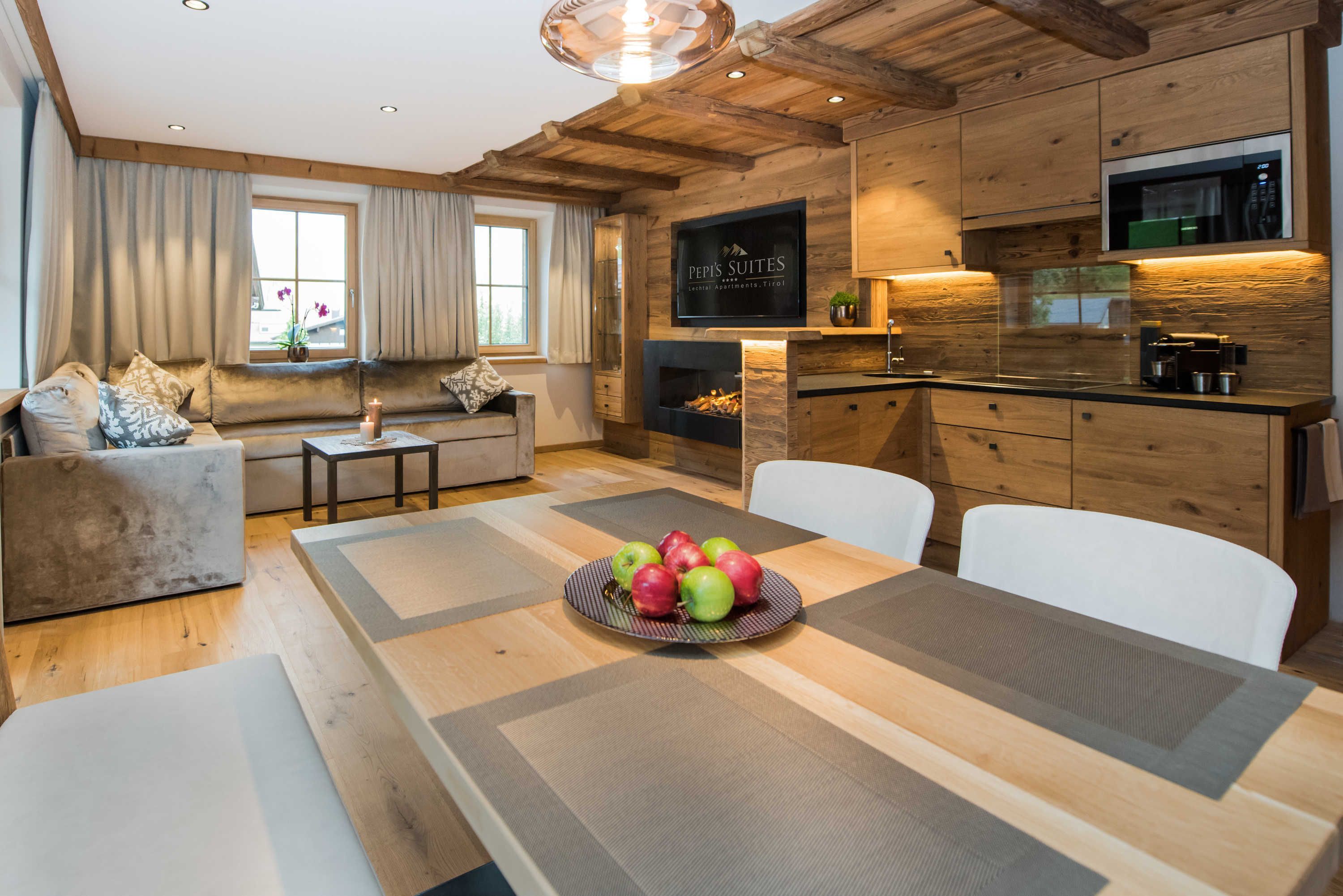 A modern kitchen with wooden cabinetry, a built-in microwave, and a dining area with a table set for four.