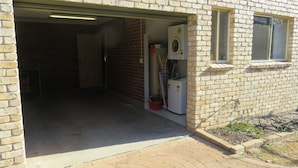 Un garage con lavatrice, una porta e una finestra.