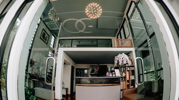 A modern interior with a central island, a staircase, and a decorative chandelier. - Step One at Bangkok (Bangkok)