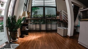 A modern kitchen with wooden flooring, a large window, and a staircase. - Step One at Bangkok (Bangkok)