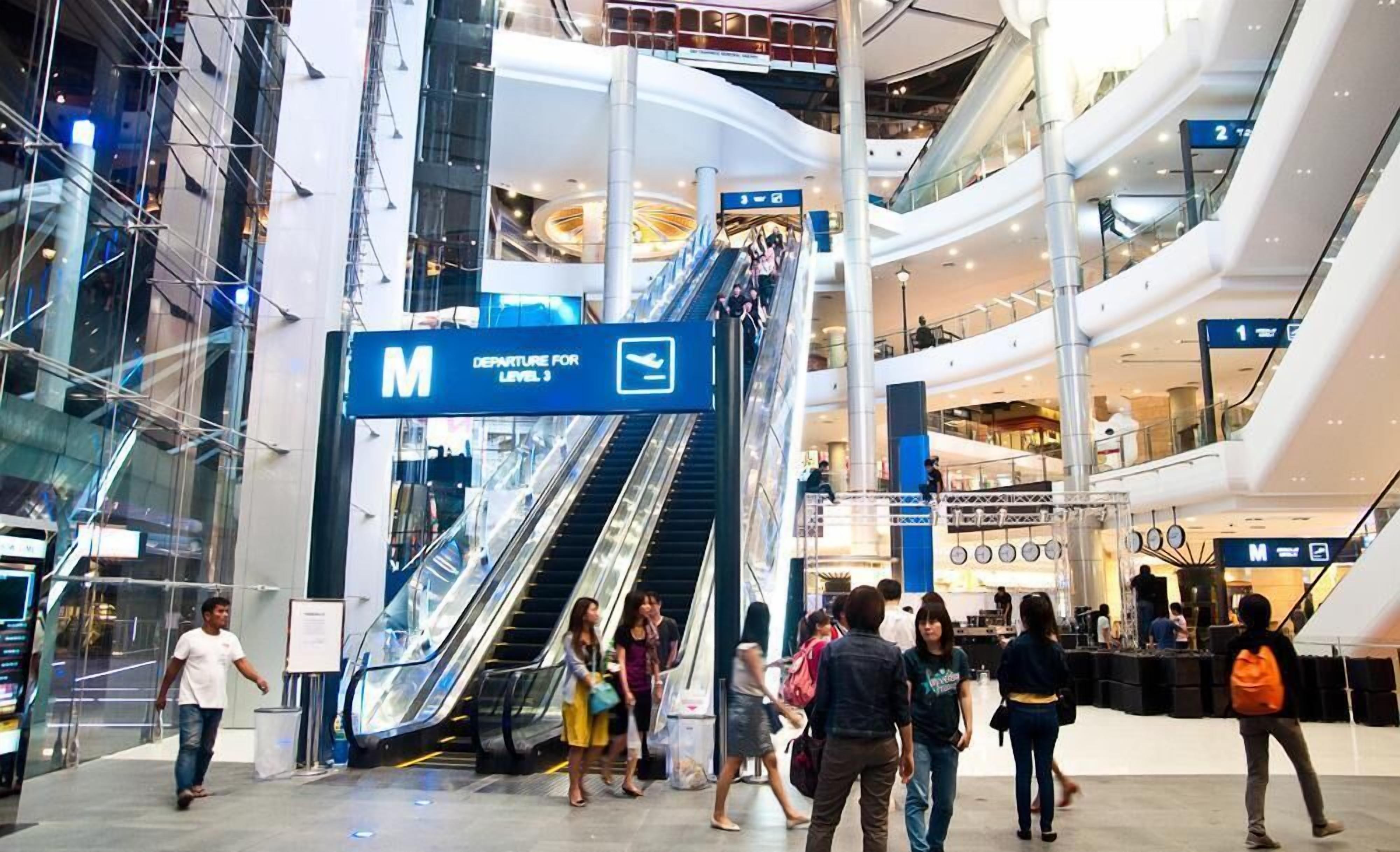 A multi-level shopping mall with escalators and signage for the M level.
