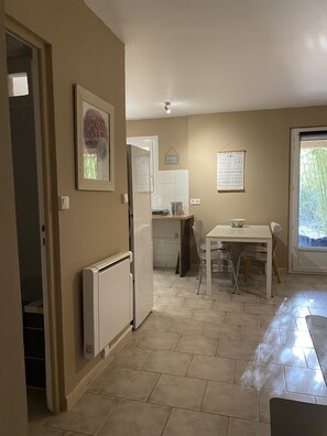 A compact kitchen with a dining area, a radiator, and a window with a view of greenery. - Gite Nino near Vallon Pt d'Arc and the village of Barjac. (Barjac)